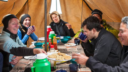 A group of travelers in Kilimanjaro enjoying a meal together.