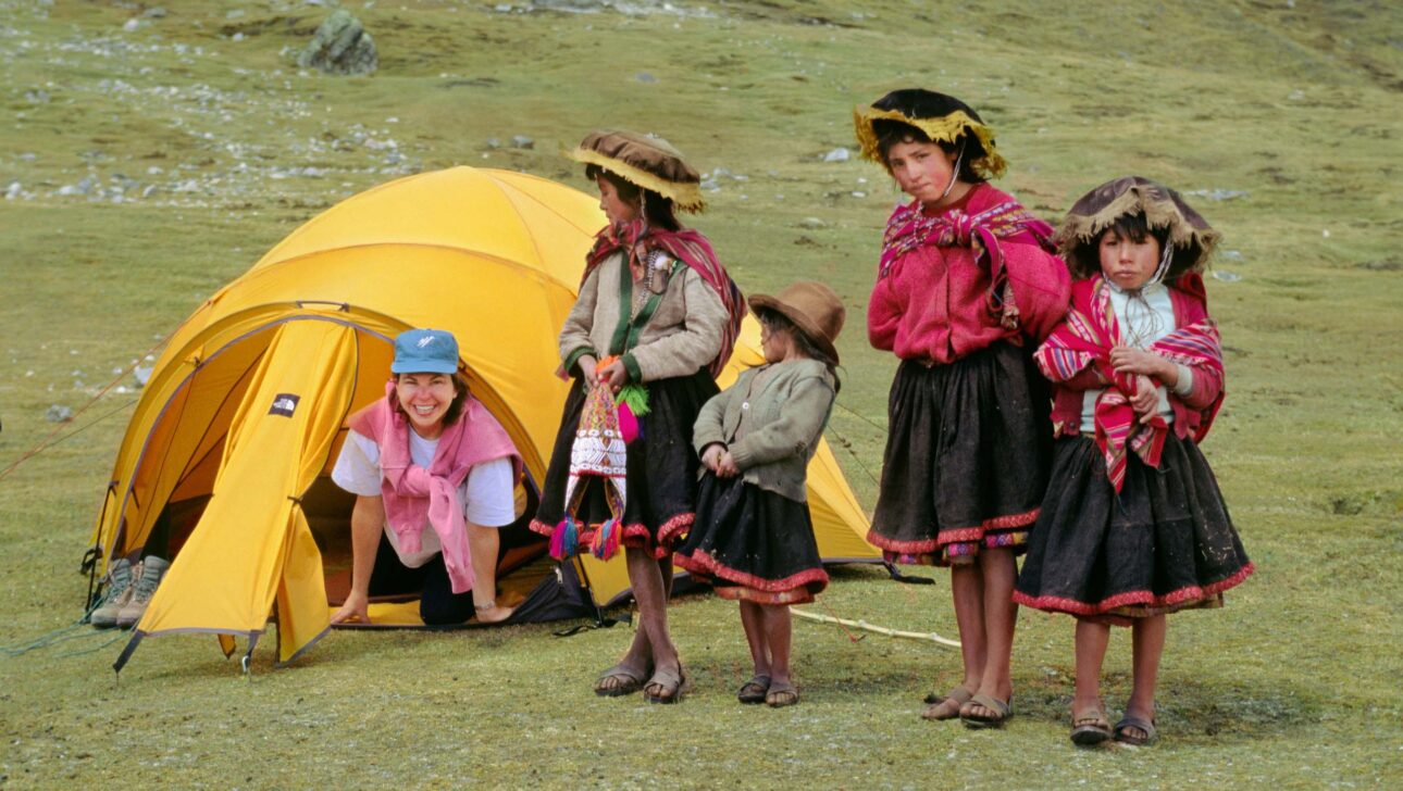 Local Quechua girls visit a trekker in her tent.