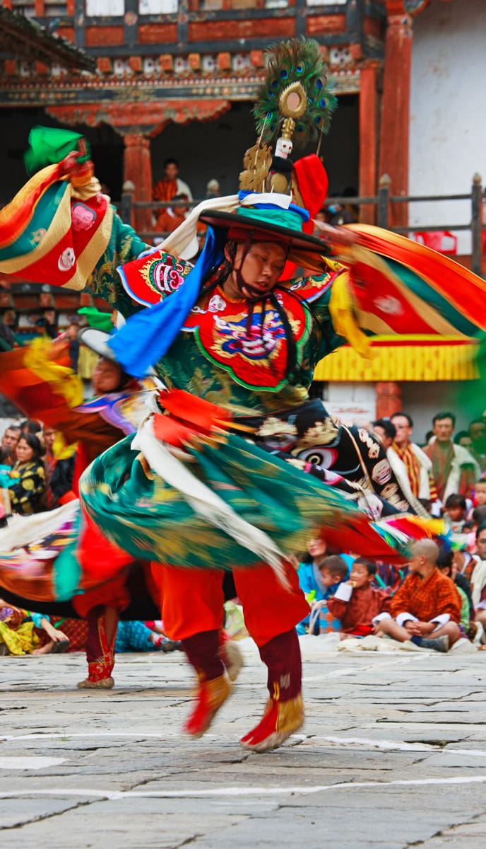 A dancer in colorful, traditional attire performs a fast-paced dance at an outdoor cultural event, captivating onlookers and perfect for featuring in a blog.